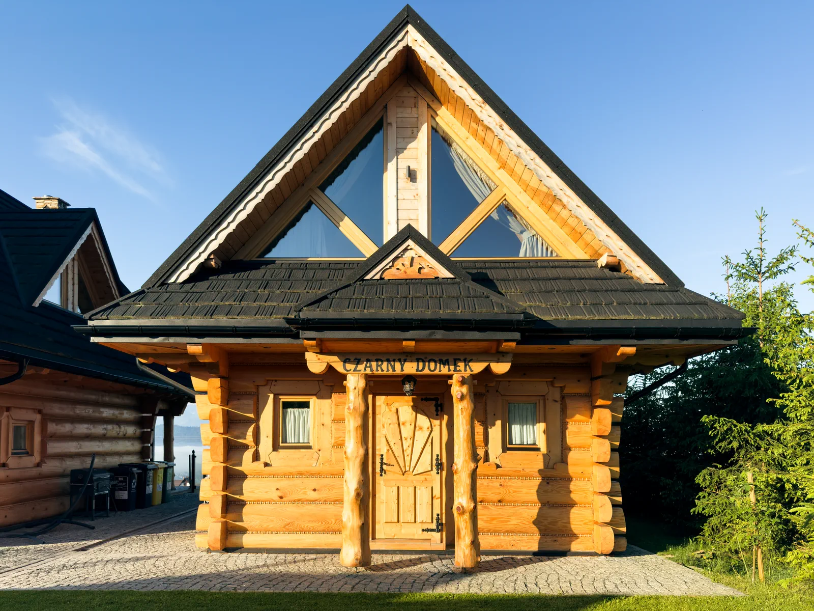 Domek Czarny – wejście i elewacja z bali, w tle Jezioro Czorsztyńskie